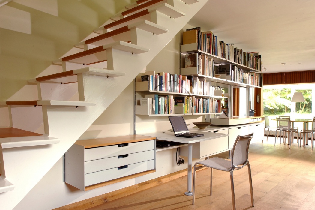 يمكن تسخير جدار غريب تحت السلالم لجدول ، أدراج ، كتب وإيداع شامل في خزانات ذات درج واحد