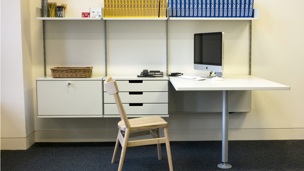 طاولة متكاملة مع خزانة هي ترتيب مفيد.  اجعل مكتبك واضحًا عن طريق نقل العمل الأقل ملاءمة إلى جانبك