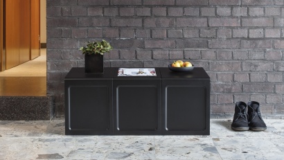 Three black tables as a bench in the hallway