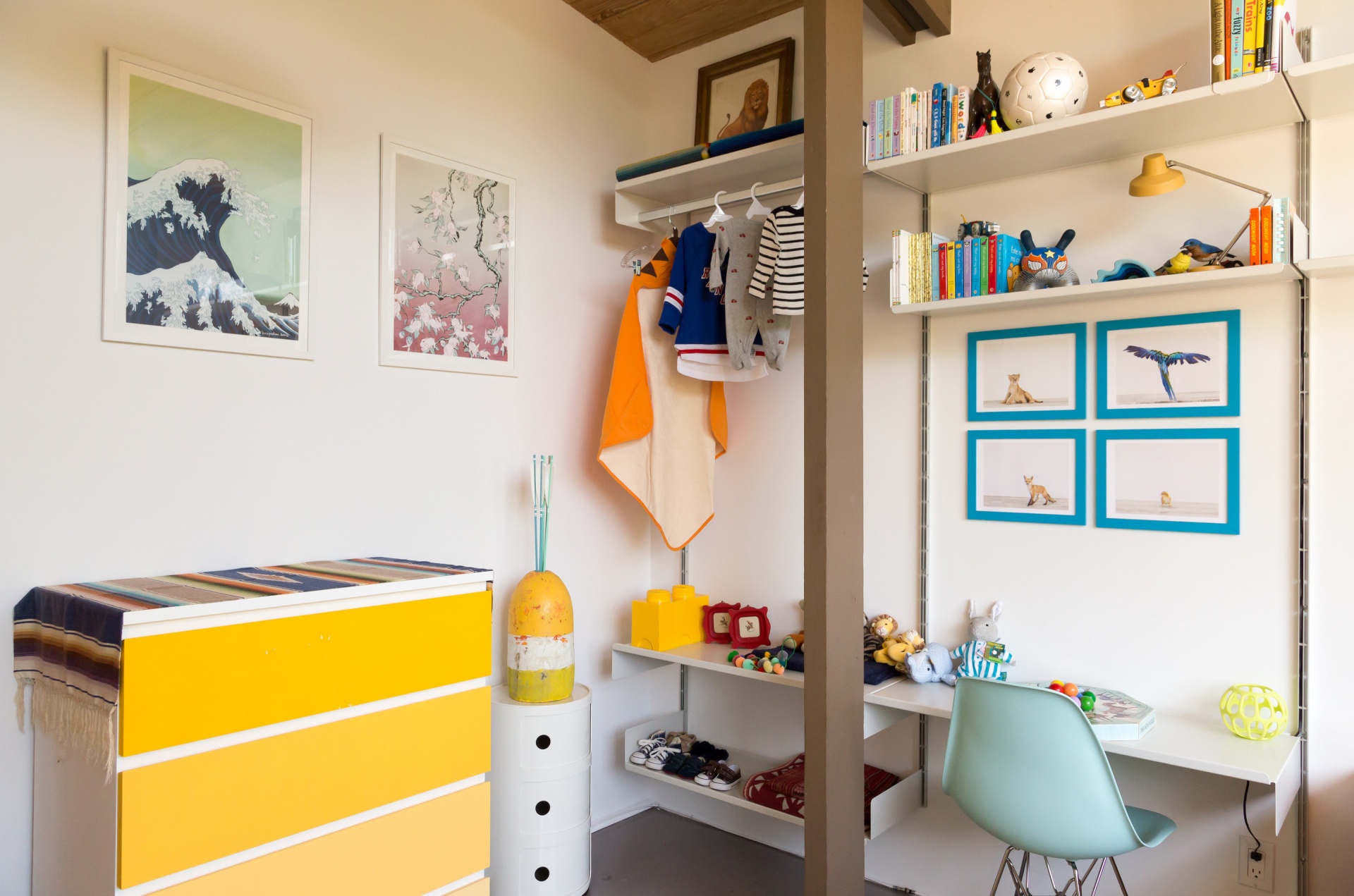 Kids room shelves in children’s nursery and playroom with strong shelves for books and toy storage. Using a shelf as a built-in kids desk. Off-white. Vitsœ 606 Universal Shelving System. Designer furniture, Dieter Rams