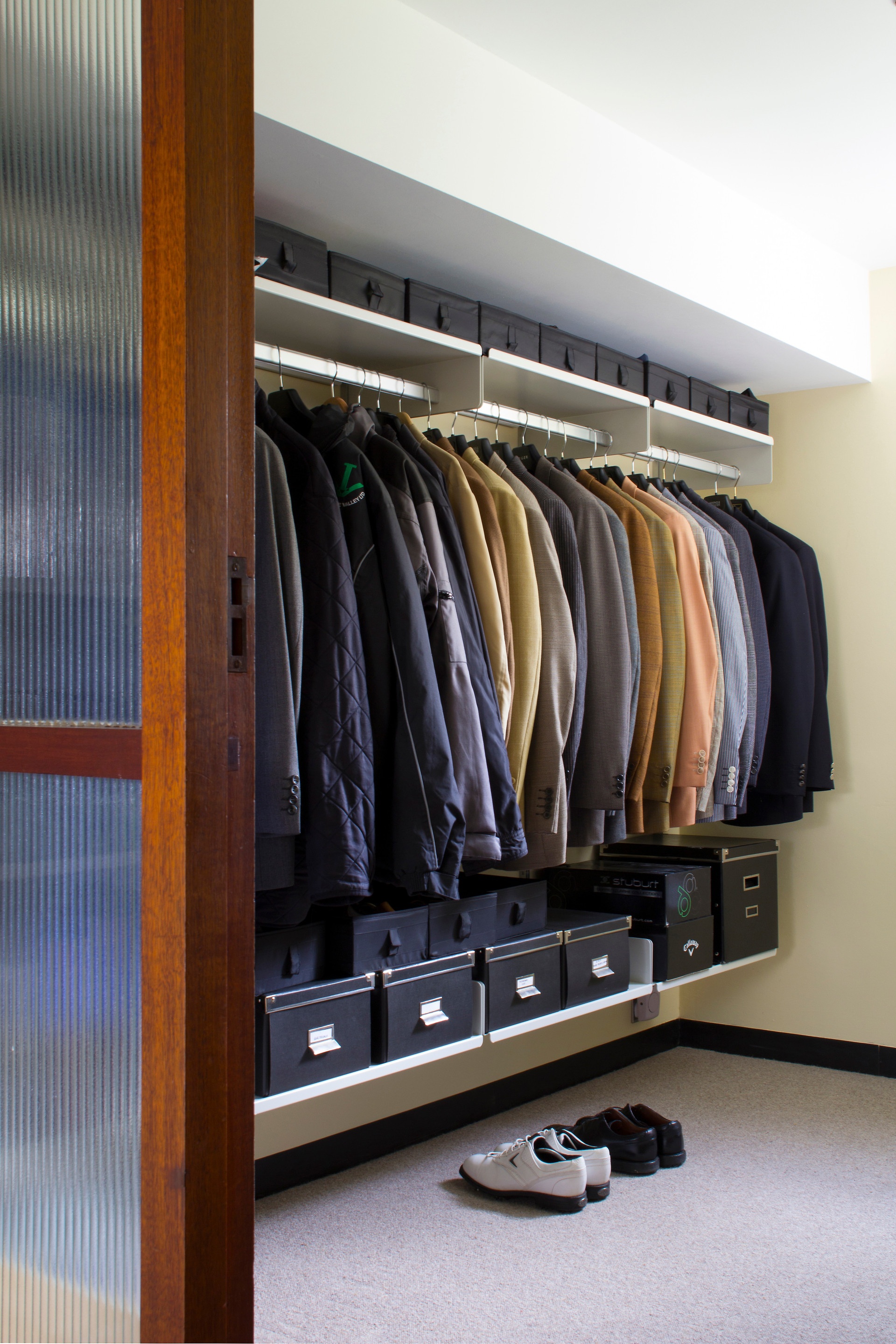 Modern walk in closet or open wardrobe system with shoe storage, shelves with strong clothes rail. Vitsœ 606 Shelving system, designer Dieter Rams.