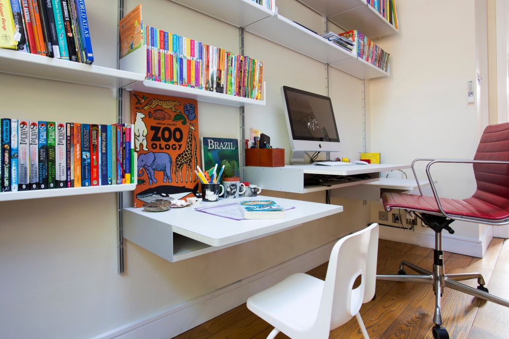 Desks at different heights for kids and grown-ups. A shelving system is for life