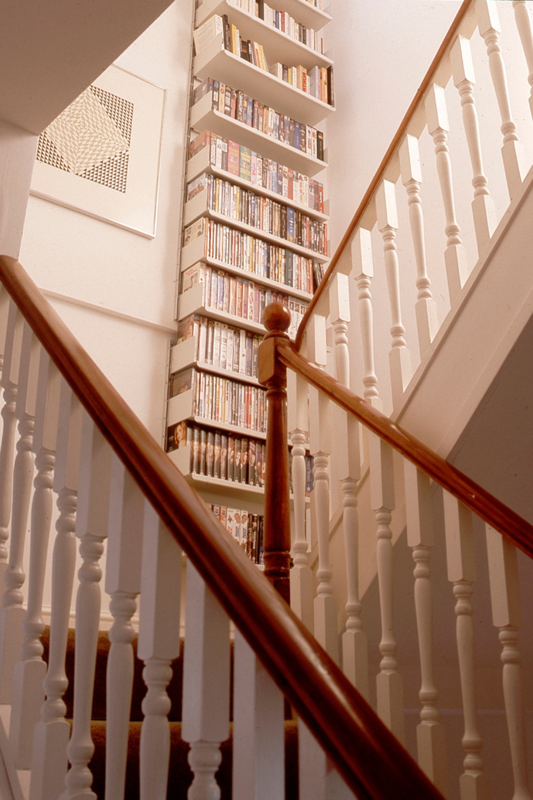 Modern wall mounted floor to ceiling bookcase. Hallway, stairs landing. Strong shelves for large collection of books. Modular 606 Shelving System. Designer, Dieter Rams. Vitsœ