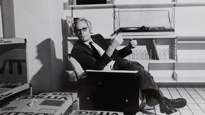Nesting pair side table. Designer reading chair, low-back, black shell. Portrait of Dieter Rams in the 620 Chair Programme, and 621 Tables in their packaging from 1962.