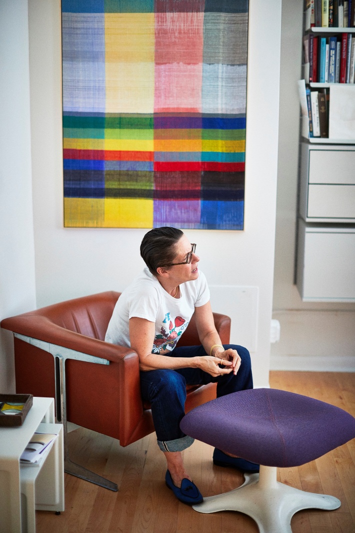 Sue Ravitz in front of her artwork and Vitsoe 606 Universal Shelving System in New York