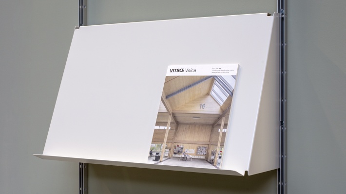 sloping shelf for art display, magazines, open books. Strong metal shelves. Vitsœ 606 modular shelving. Designer Dieter Rams