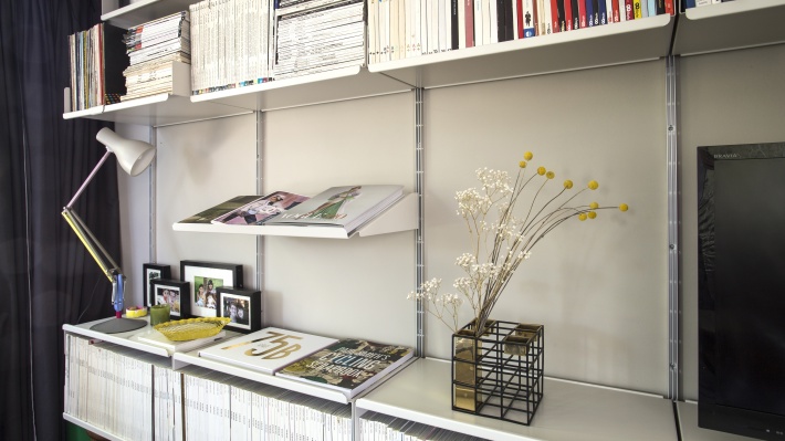 sloping shelf for displaying an open book. Strong metal shelves. Vitsœ 606 modular shelving. Designer Dieter Rams