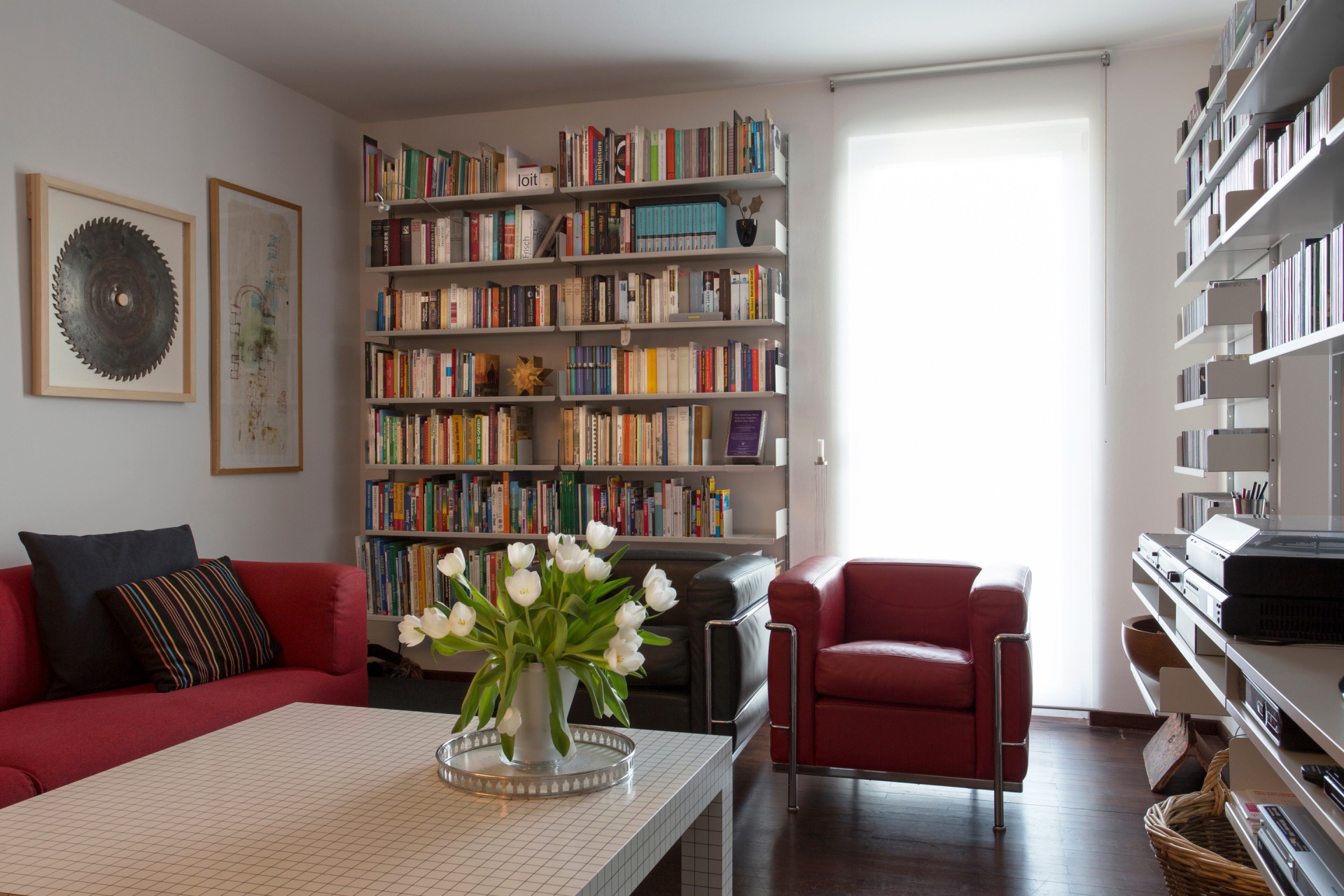 Library bookshelf in Living room. Wall mounted shelving for LP record player, vinyl, media. Vitsœ Modular 606 Universal Shelving System. Designer shelves, Dieter Rams