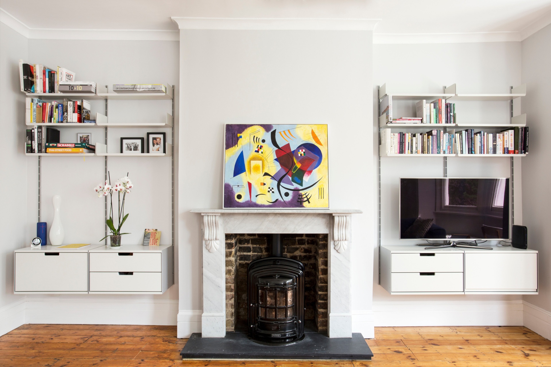 TV stand and bookshelves in the alcove,  living room.  Wall mounted, off-white. Vitsœ Modular 606 Universal Shelving System. Designer shelves, Dieter Rams