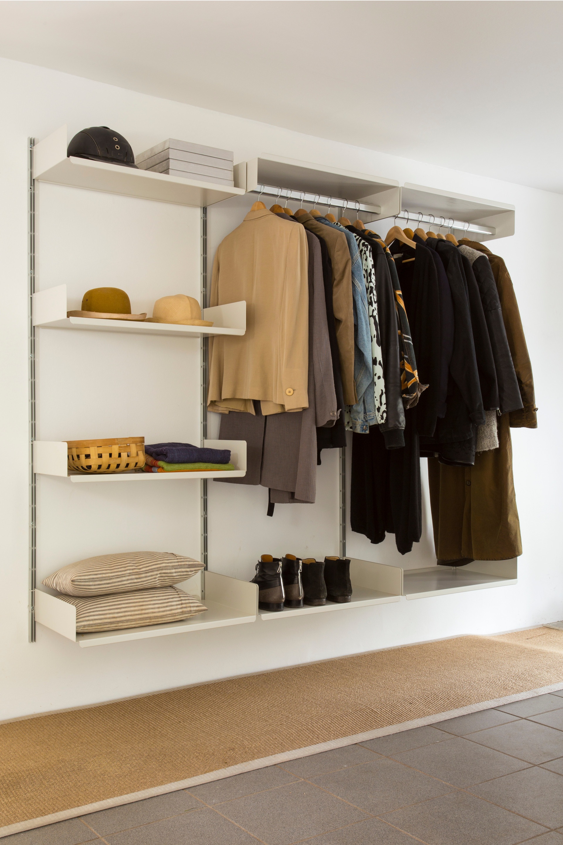Stylish open wardrobe system with strong clothes rail shelves and shoe storage. Hallway. Vitsœ modular 606 Shelving system, designer Dieter Rams.