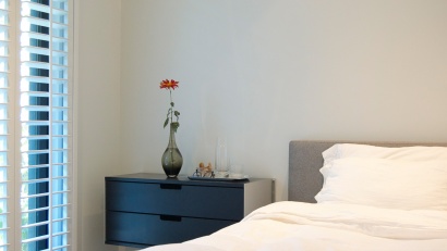 Modern black wall mounted bedside table. Two drawer floating cabinet, clothes storage for small bedroom. Custom made. Vitsœ modular 606 Shelving system, designer Dieter Rams.