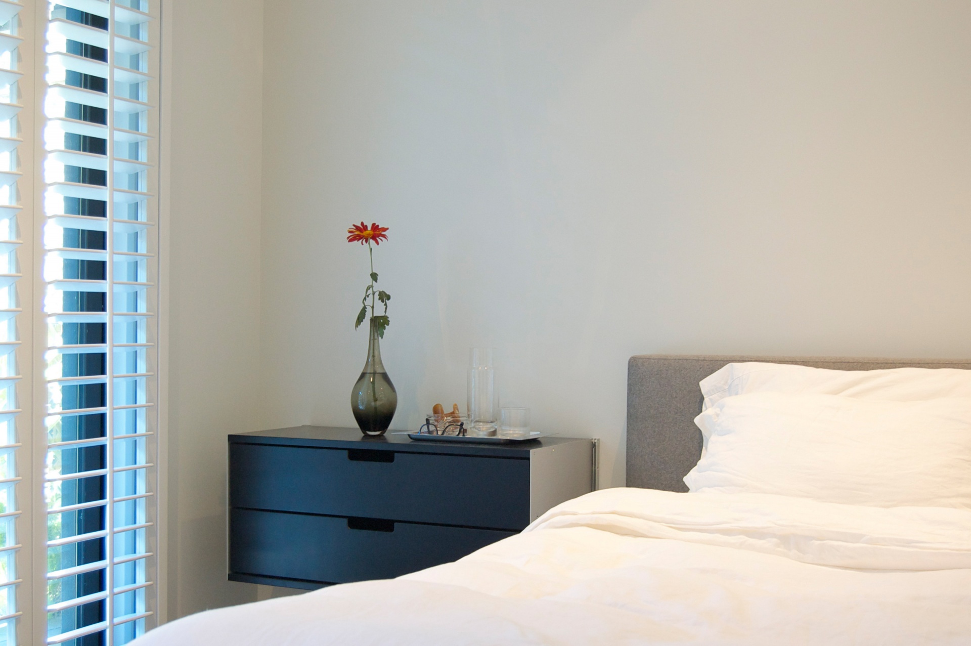 Modern black wall mounted bedside table. Two drawer floating cabinet, clothes storage for small bedroom. Custom made. Vitsœ modular 606 Shelving system, designer Dieter Rams.