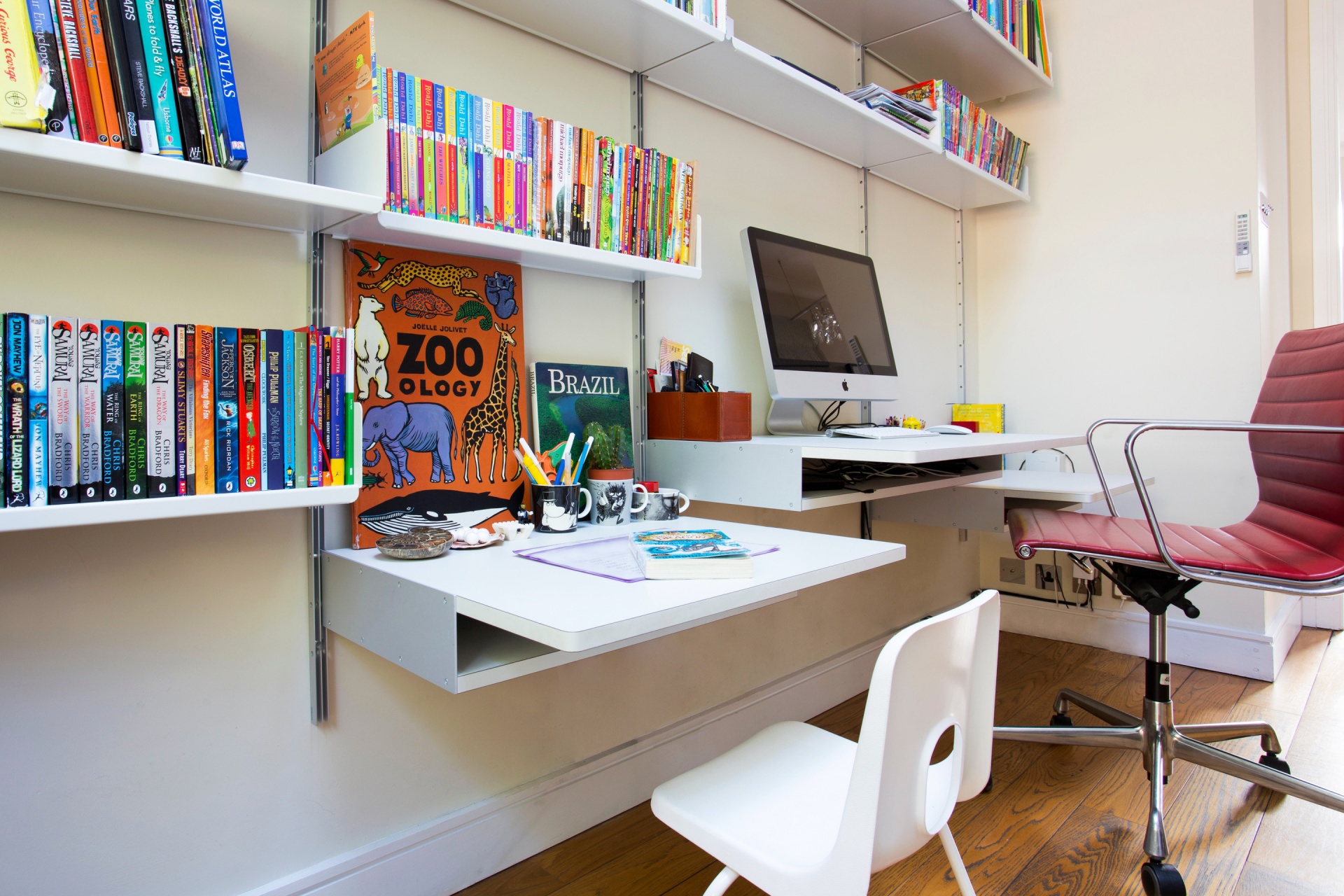 Kids and adults workstation for living room, home office set up. Adjustable height desks, modern, customisable design work space.Modular wall mounted bookshelf. Off-white. Vitsœ 606 Universal Shelving System. Designer furniture, Dieter Rams