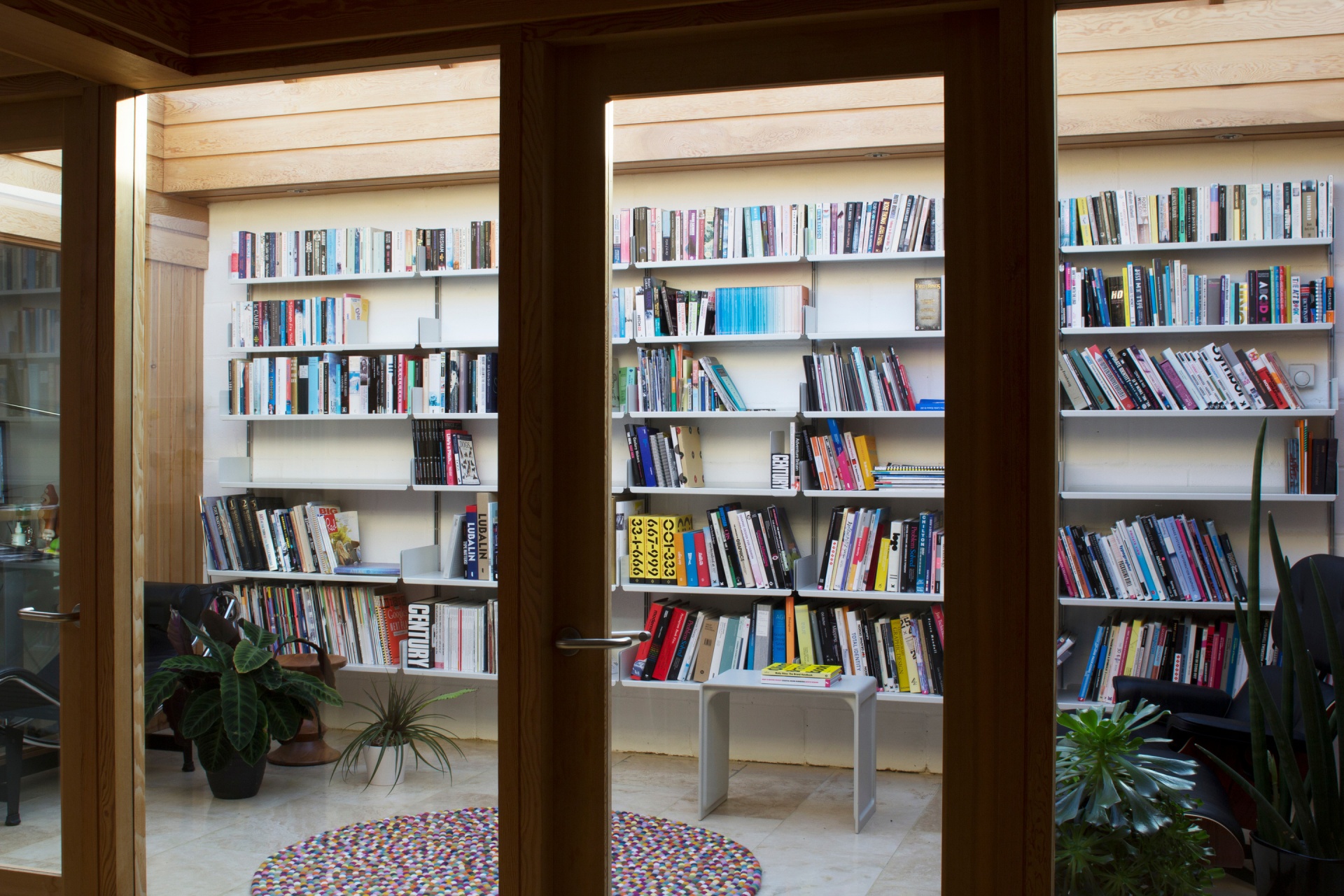 Wall mounted bookshelves. White bespoke bookcase. Large collection. Designer shelves, Dieter Rams. Vitsœ 606 Universal Modular Shelving System.