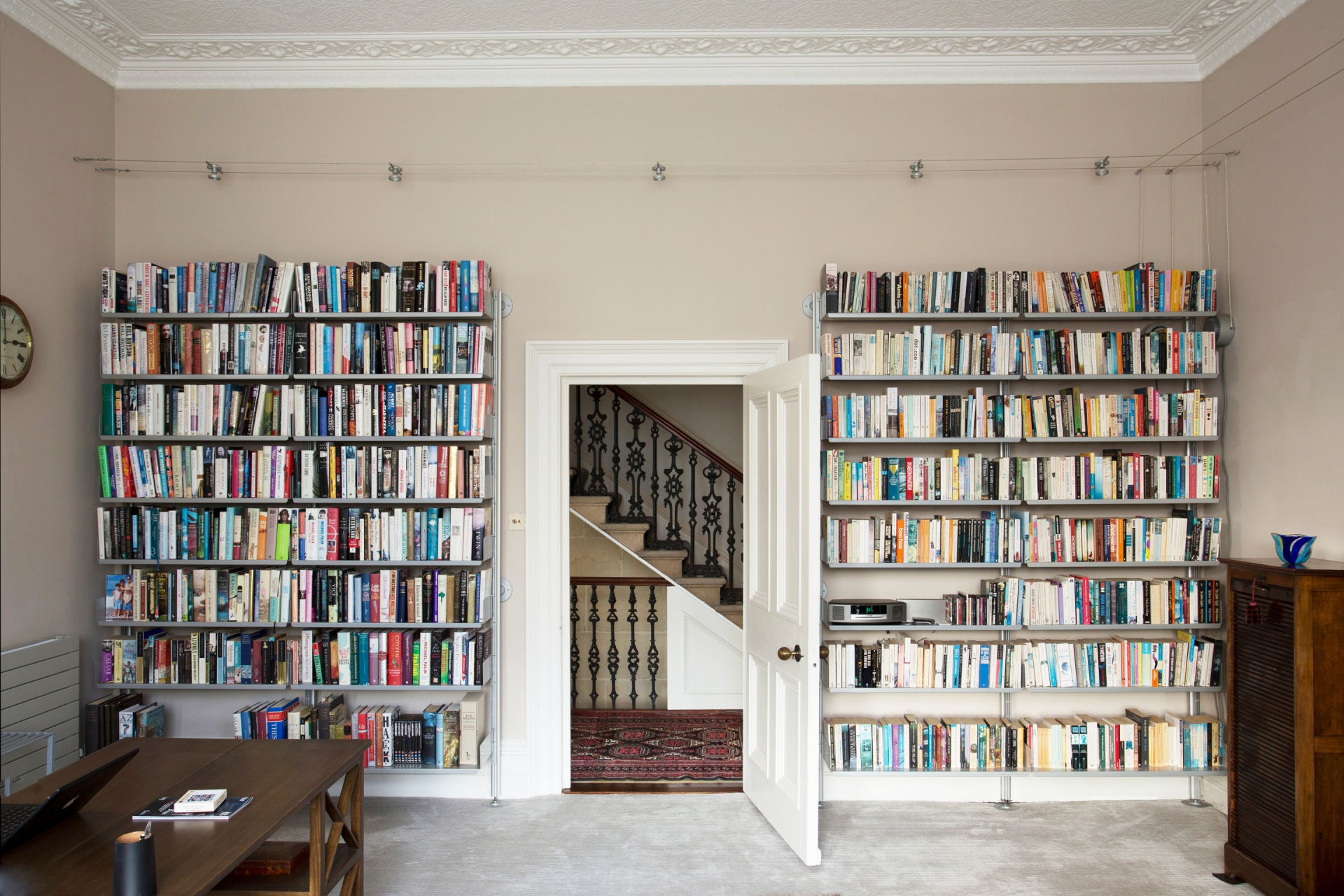 Large wall-mounted bookshelves, 2 white metal bookcases. Custom solutions for book storage. Designer shelves, Dieter Rams. Vitsœ 606 Universal Modular Shelving System.