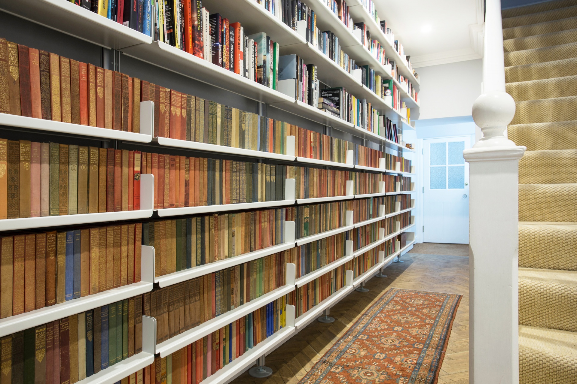 Large custom made hallway bookshelves, floor to ceiling.  Strong metal. 606 Modular Shelving System. Designer, Dieter Rams. Vitsœ