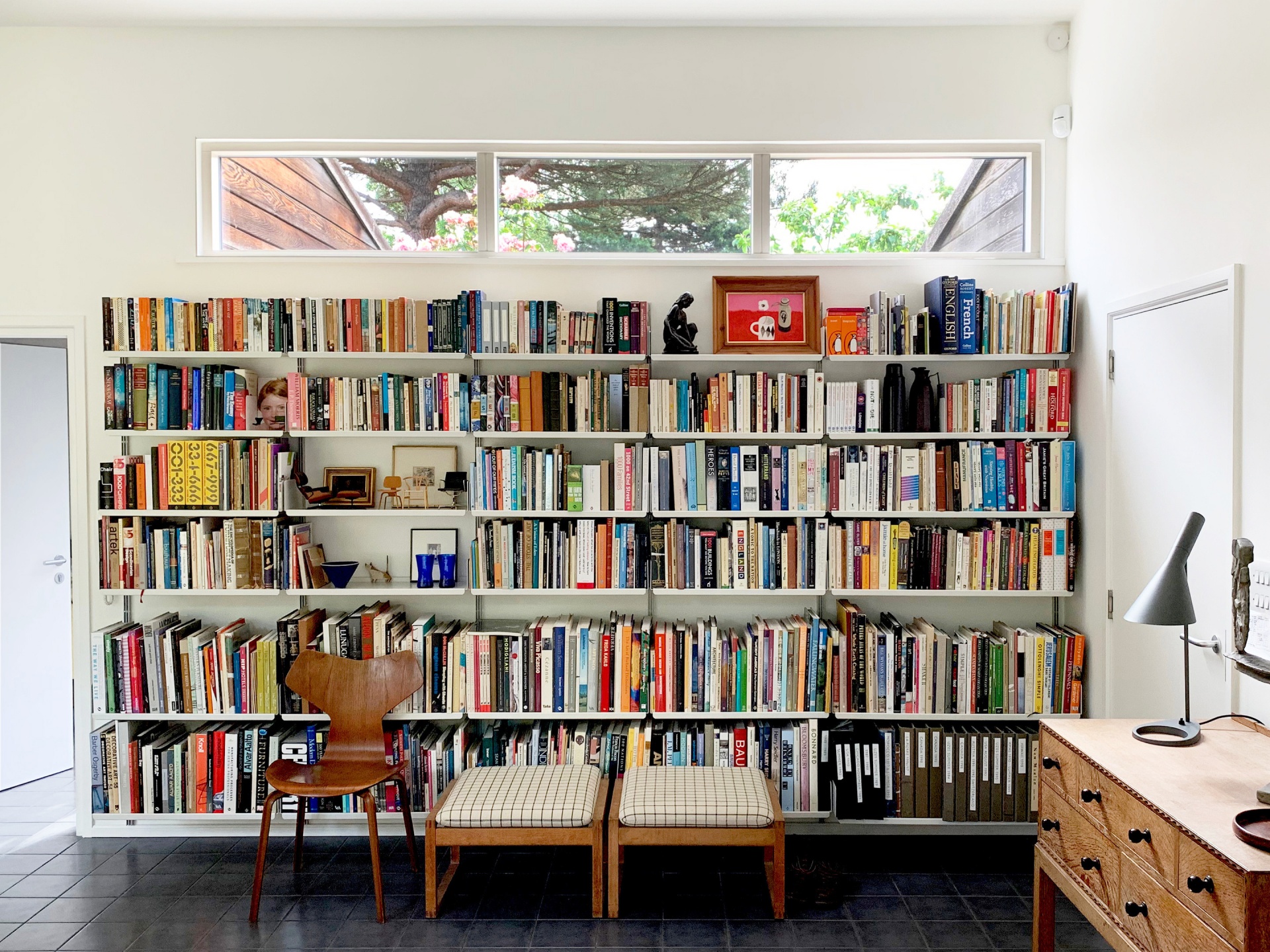 Floor to ceiling bookshelves. Wall mounted bookcases. Strong metal shelves for heavy collection of books, living room. Designer shelves, Dieter Rams. Vitsœ 606 Universal Modular Shelving System.