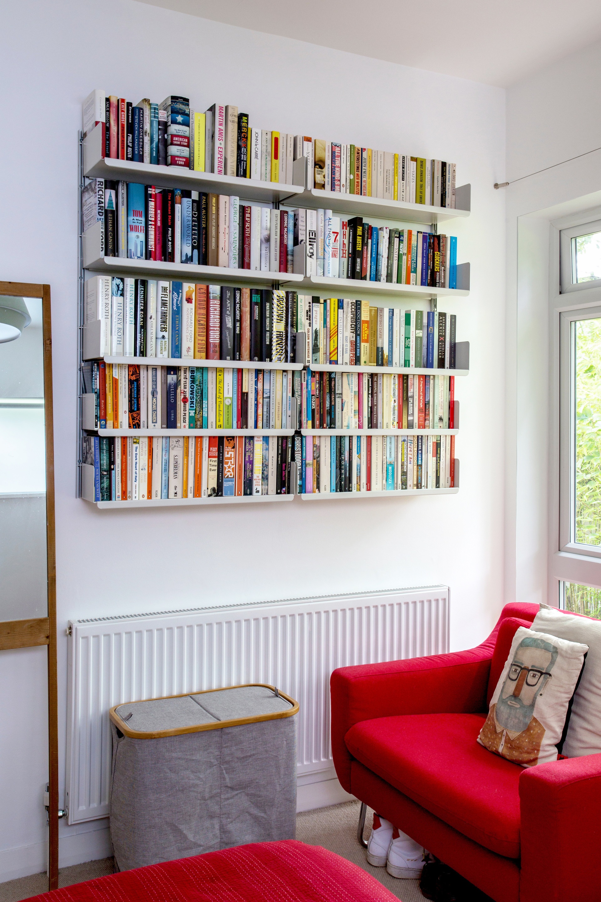 Wall mounted bookshelves. White bespoke bookcase. Above radiator. Designer shelves, Dieter Rams. Vitsœ 606 Universal Modular Shelving System.