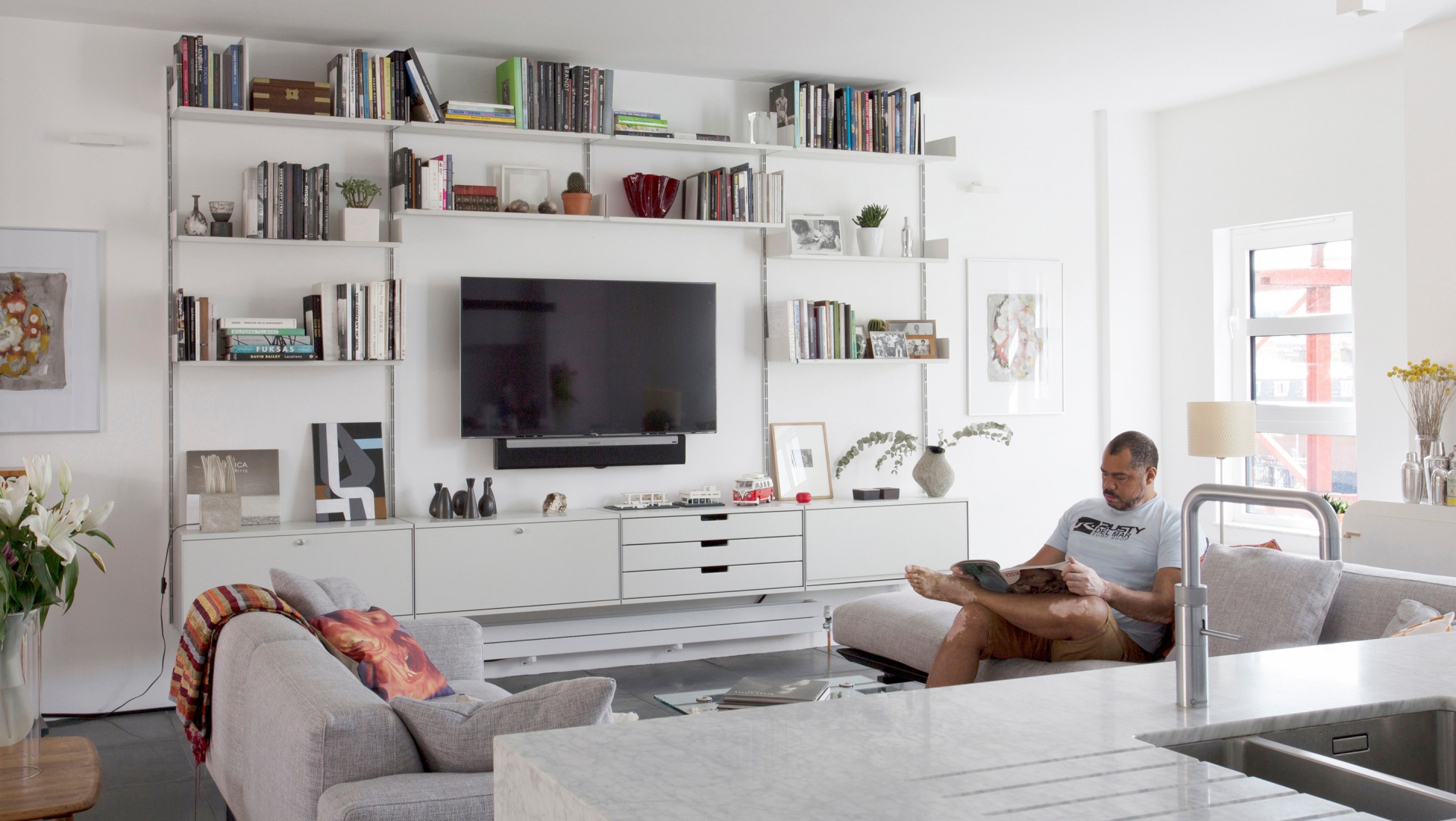 TV stand sideboard and bookshelves combination. TV mounted. Minimalist modular 606 shelving system. Designer Dieter Rams. Vitsœ
