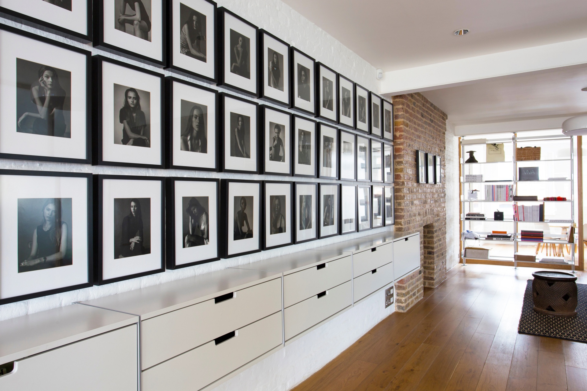 live work space, filing drawer cabinets, wall mounted. Floor to ceiling bookshelf in the background, office room divider modular shelving system. Vitsœ 606. Designer shelves Dieter Rams.