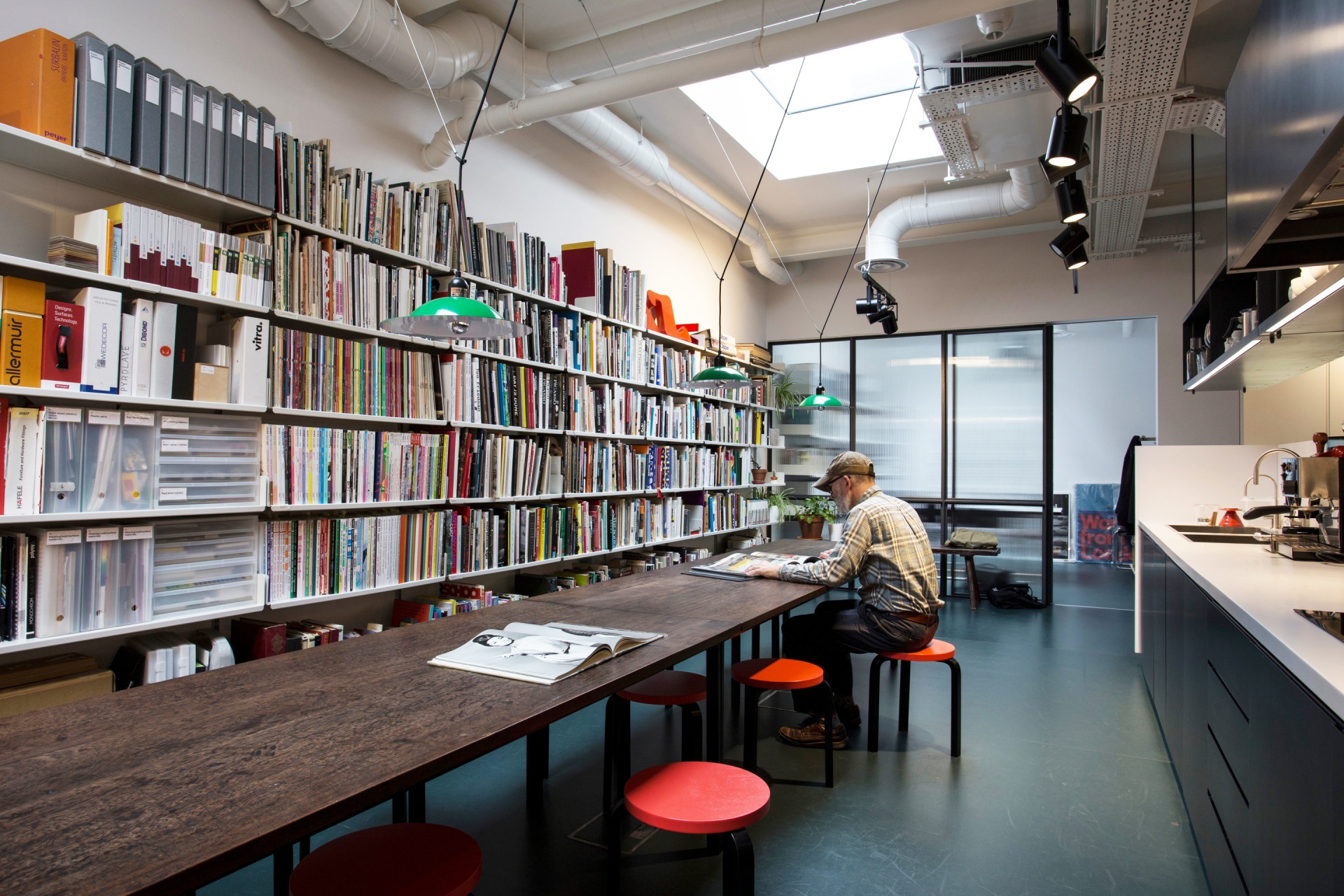 live work space, floor to ceiling bookshelves, white, metal. 30cm filing shelves. Vitsœ 606 modular shelving system. Designer shelves Dieter Rams.