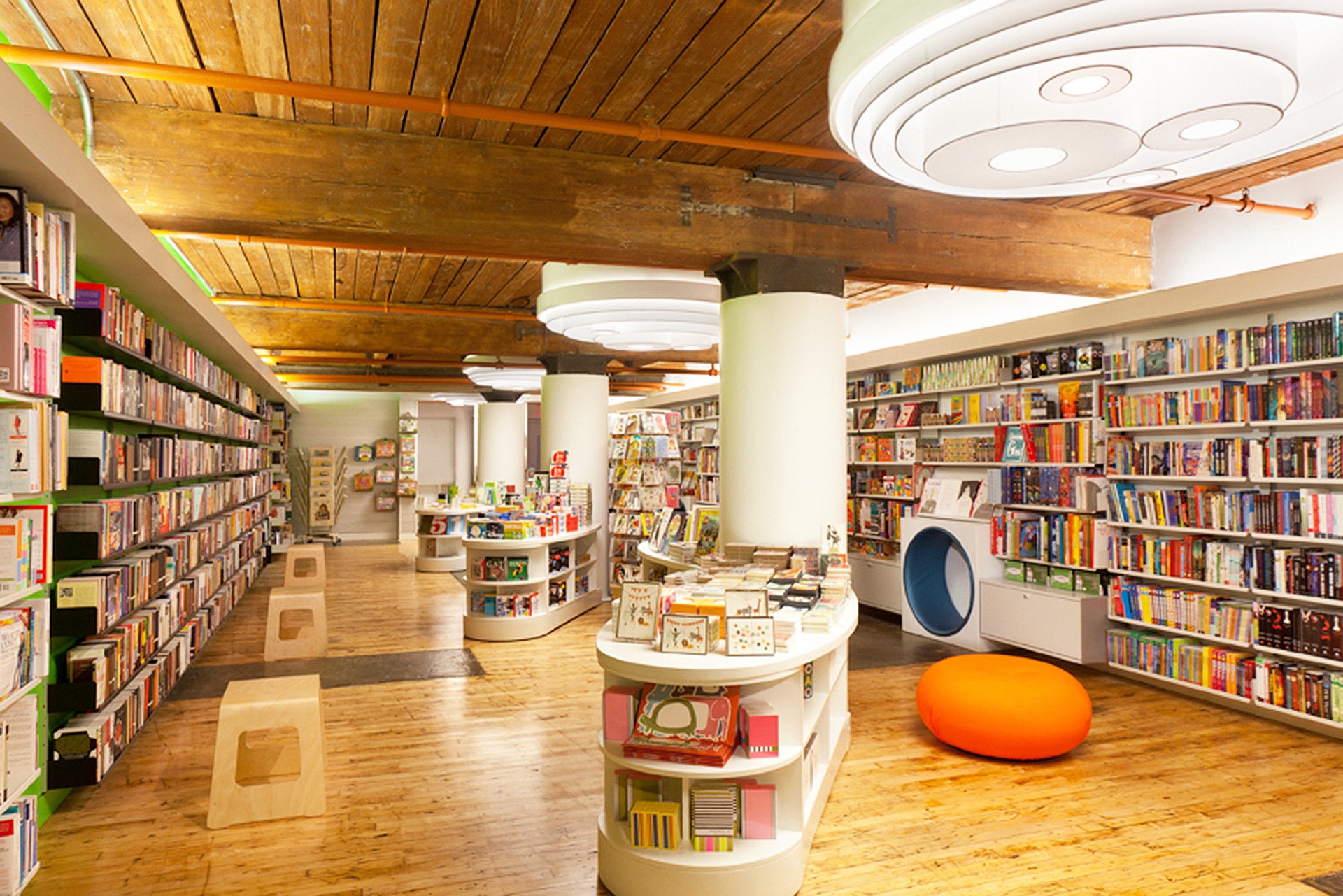 Shop display shelving. Modern bookstore. Off-white, metal. Wall mounted. Vitsœ 606 Universal Modular Shelving System. Design Dieter Rams