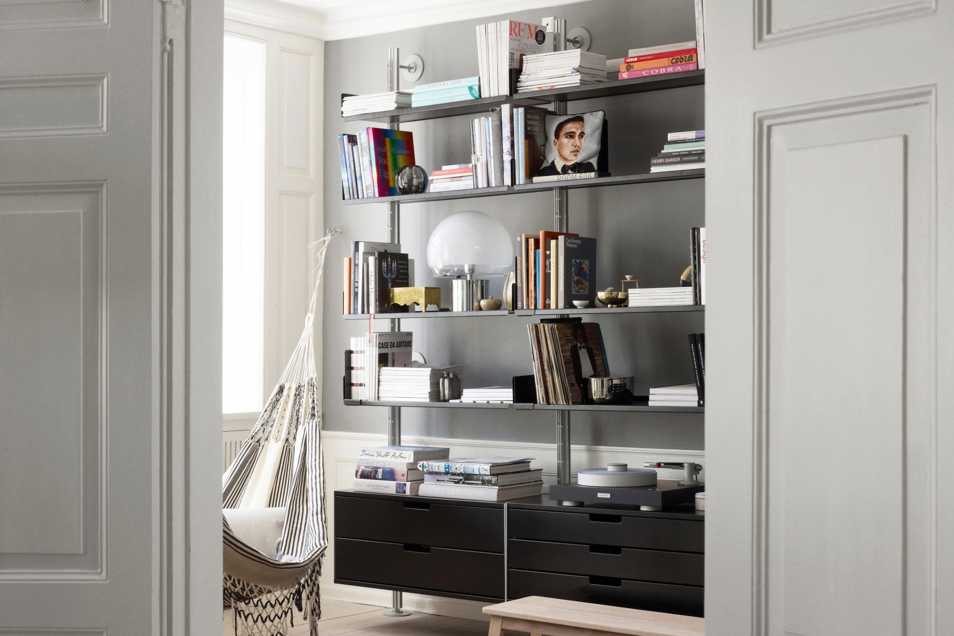 Modern bookstore display shelving and drawer cabinets. Floor to ceiling strong shelves in black metal. Vitsœ 606 Universal Modular Shelving System. Design Dieter Rams