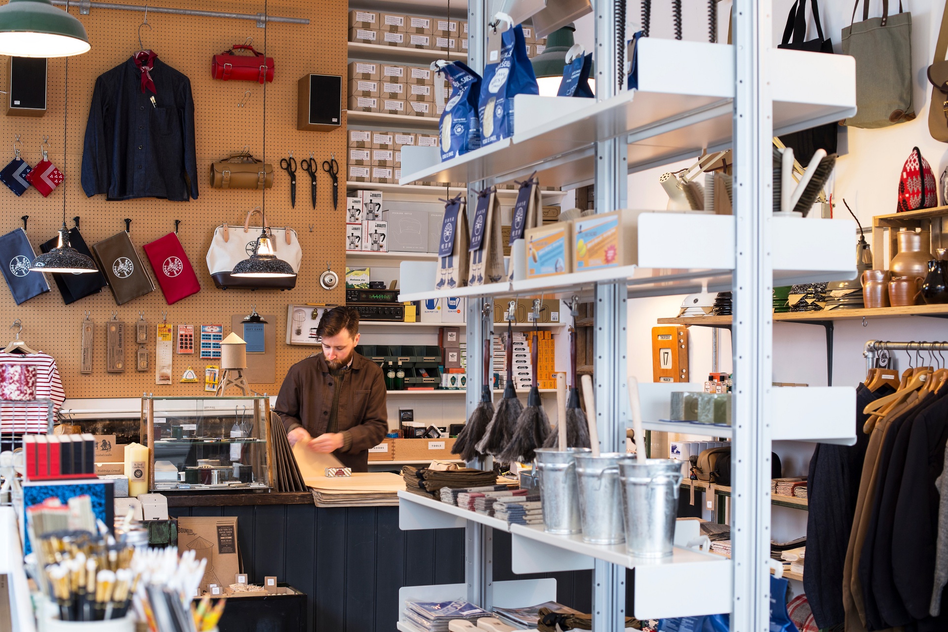 Modern shop display shelving, retail. Compressed floor to ceiling, off-white strong metal. Vitsœ 606 Universal Modular Shelving System. Design Dieter Rams