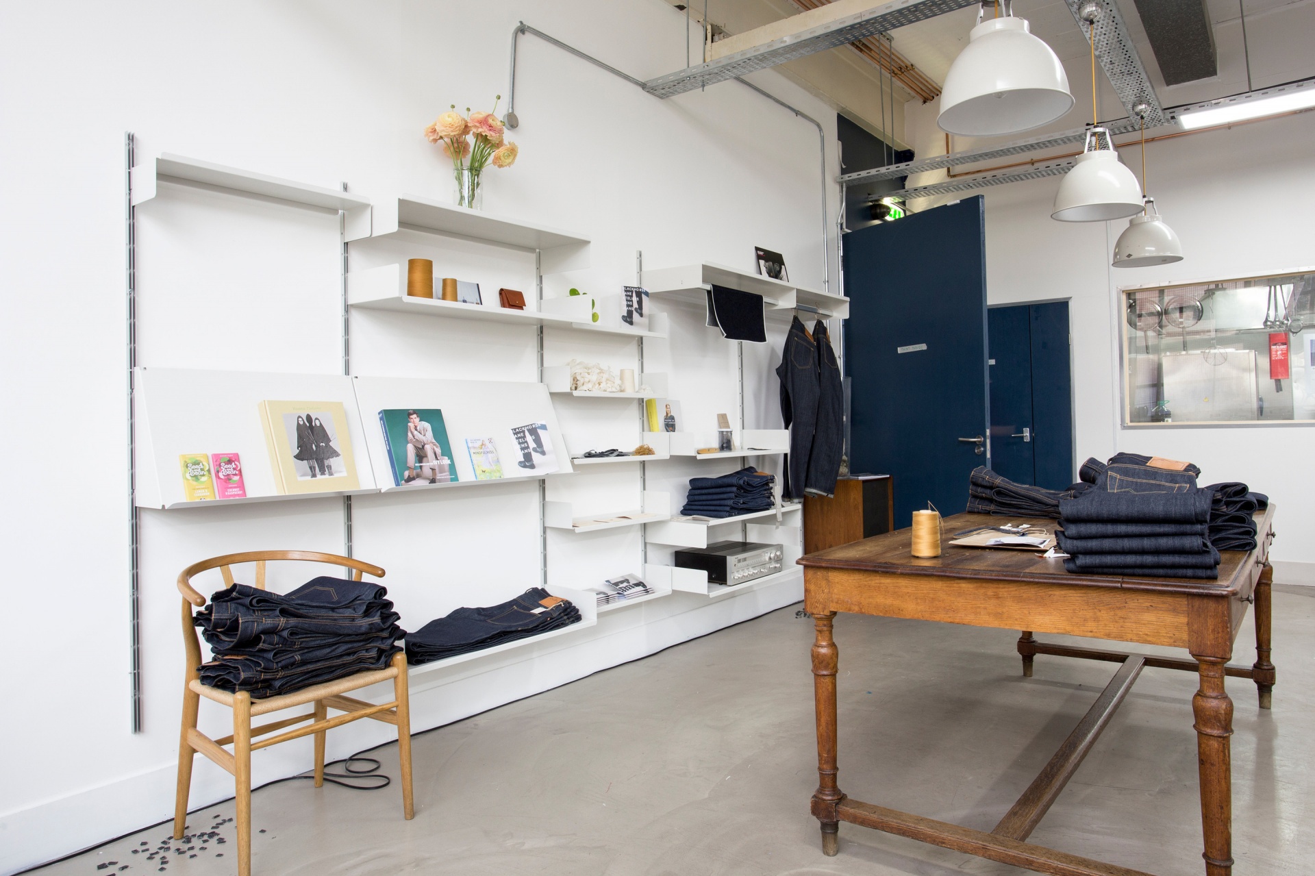 Minimalist modern shop display shelving. off-white strong metal shelves for retail. Wall mounted. Vitsœ 606 Universal Modular Shelving System. Design Dieter Rams