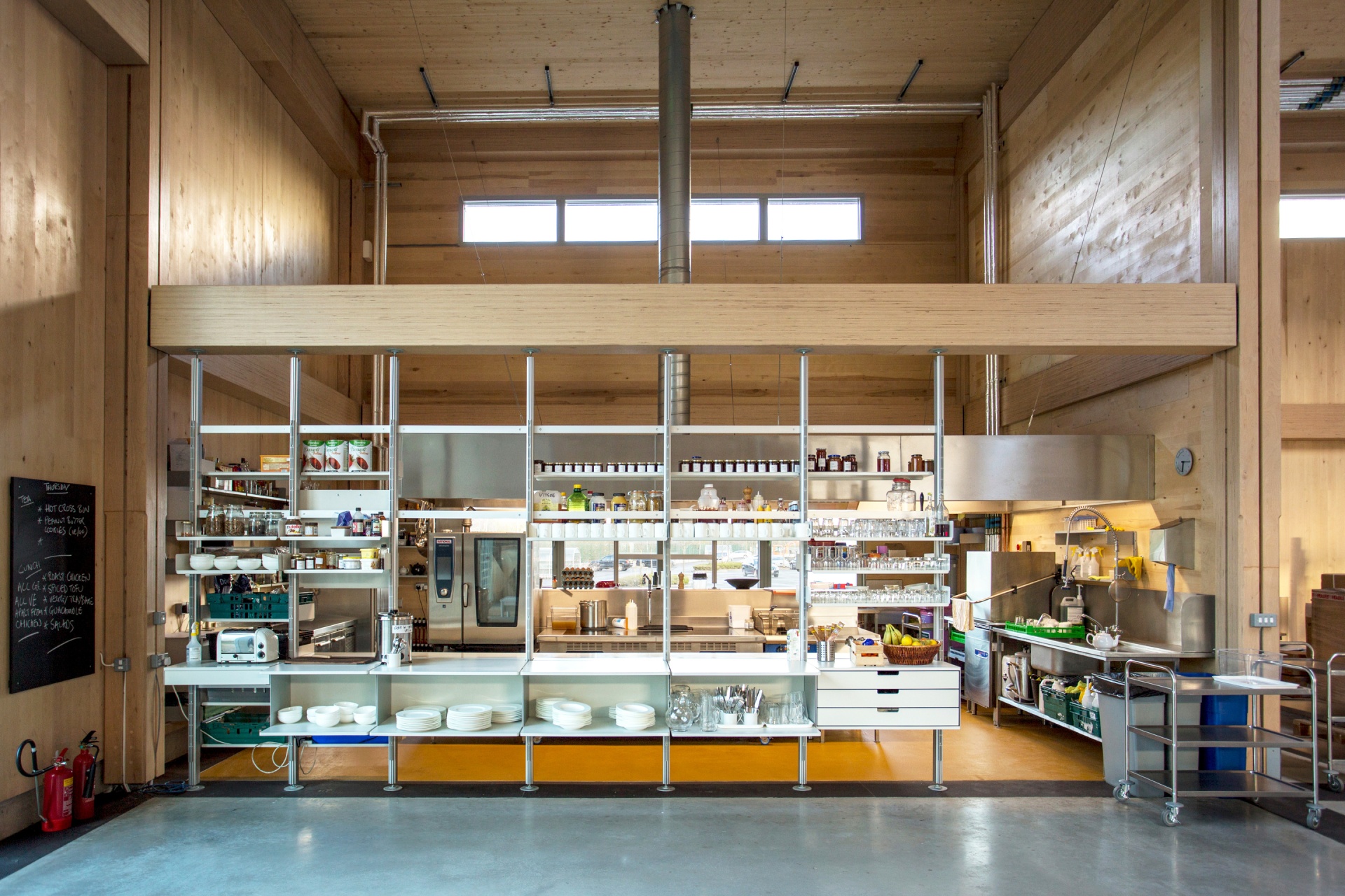 Restaurant shelving. Service counter with  strong shelves and cabinets at Vitsœ HQ in off-white metal. Modular 606 Universal Shelving System. Design Dieter Rams