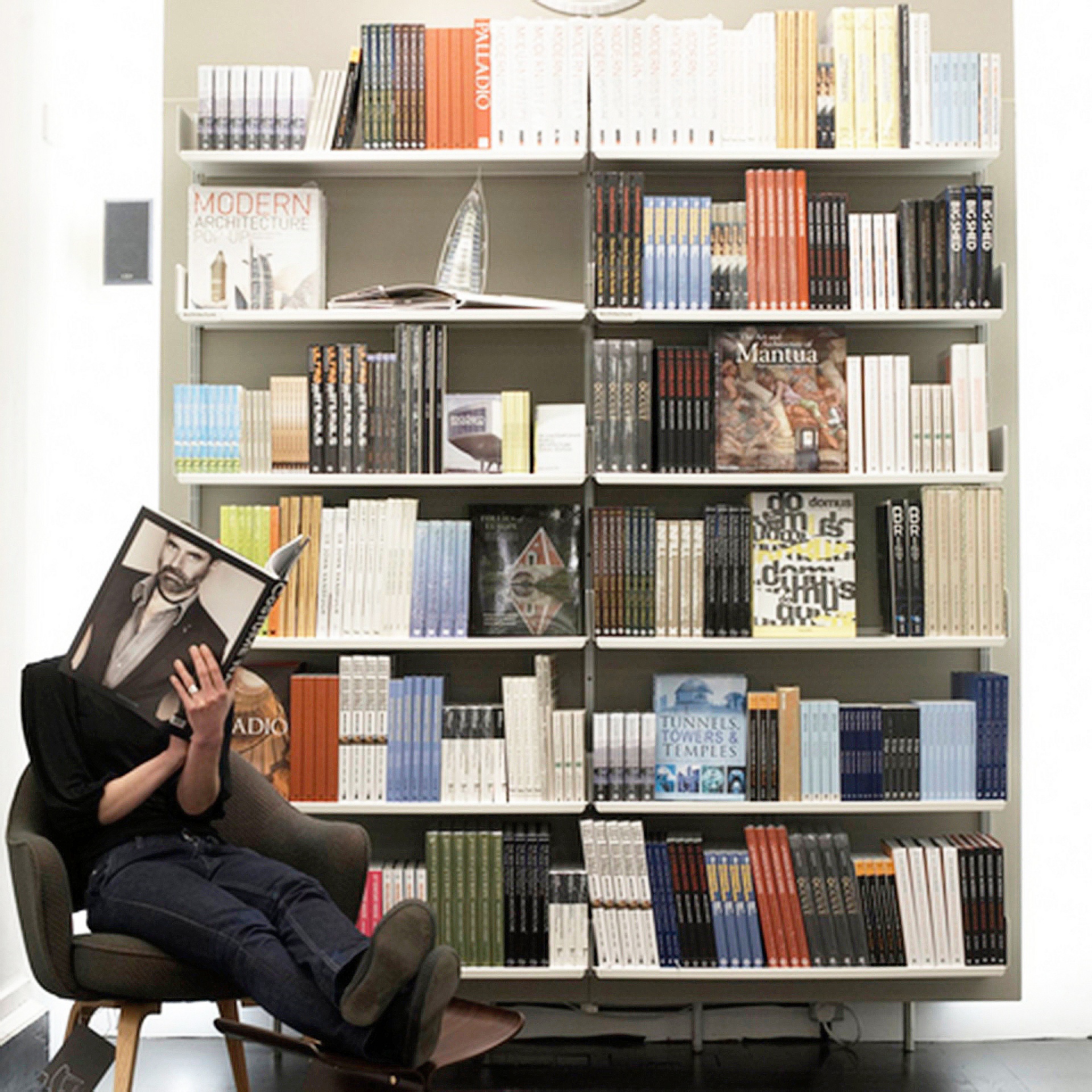 Museum library shelving, book retail display shelves in off-white metal. Modern wall mounted bookshelves. Modular Vitsœ 606 Universal Shelving System. Design Dieter Rams