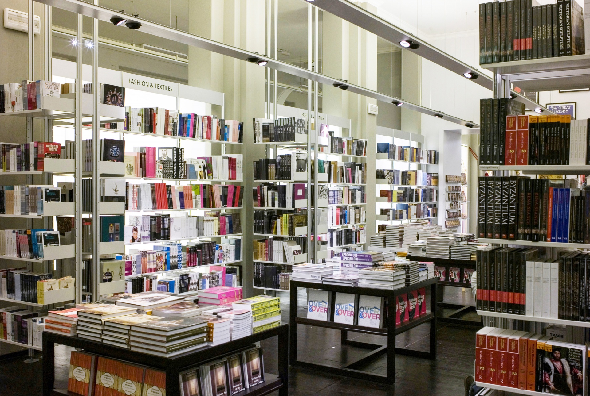 Museum library shelving, book display. Floor to ceiling compressed system in off-white metal. Modern wall mounted bookshelves. Modular Vitsœ 606 Universal Shelving System. Design Dieter Rams