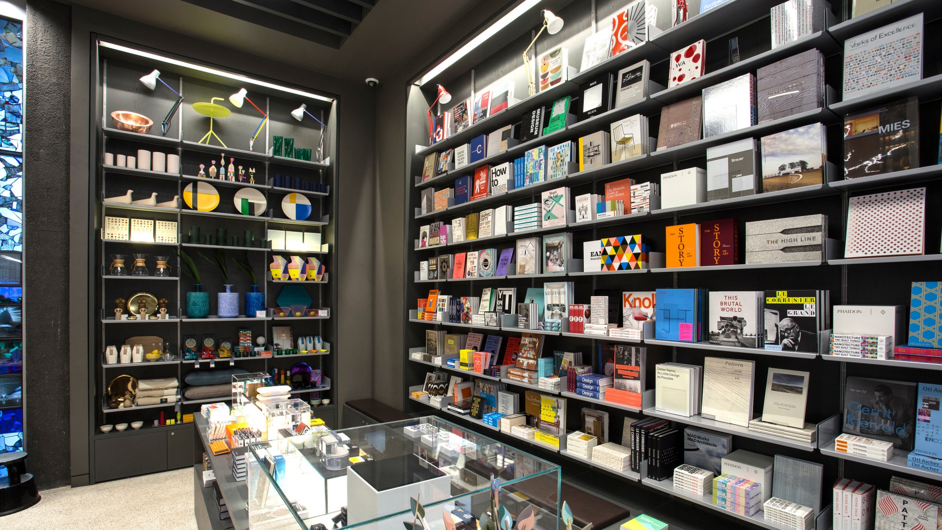 Museum library shelving, book and art retail display shelves in silver metal. Modern wall mounted bookshelves. Floor to ceiling. Modular Vitsœ 606 Universal Shelving System. Design Dieter Rams