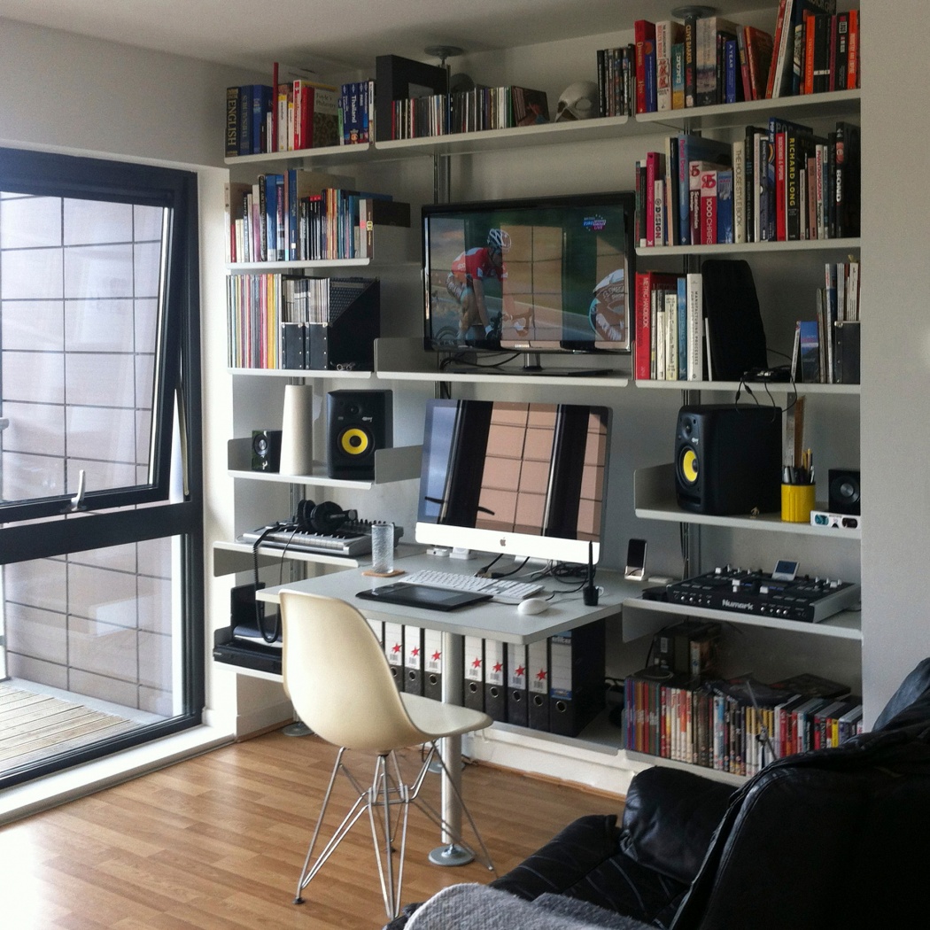 Modular shelving system with desk and strong shelves for big collection of books, TV stand, media and box file storage. Above desk shelving unit in off-white, wall-mounted bookshelf for modern home office in the living room. Designer shelves, Dieter Rams. Vitsœ 606 Universal Shelving System.