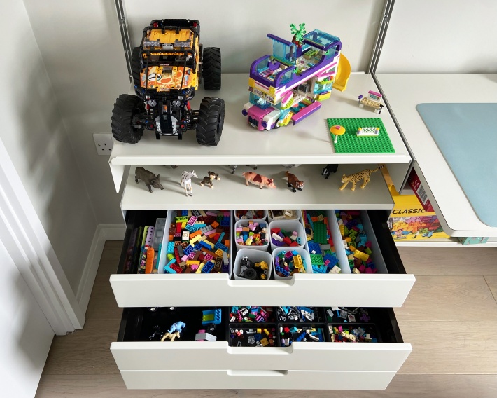 Vitsoe 606 shelving system for kids bedroom. Three drawer cabinet open. Wall mounted, off-white. Dieter Rams design.