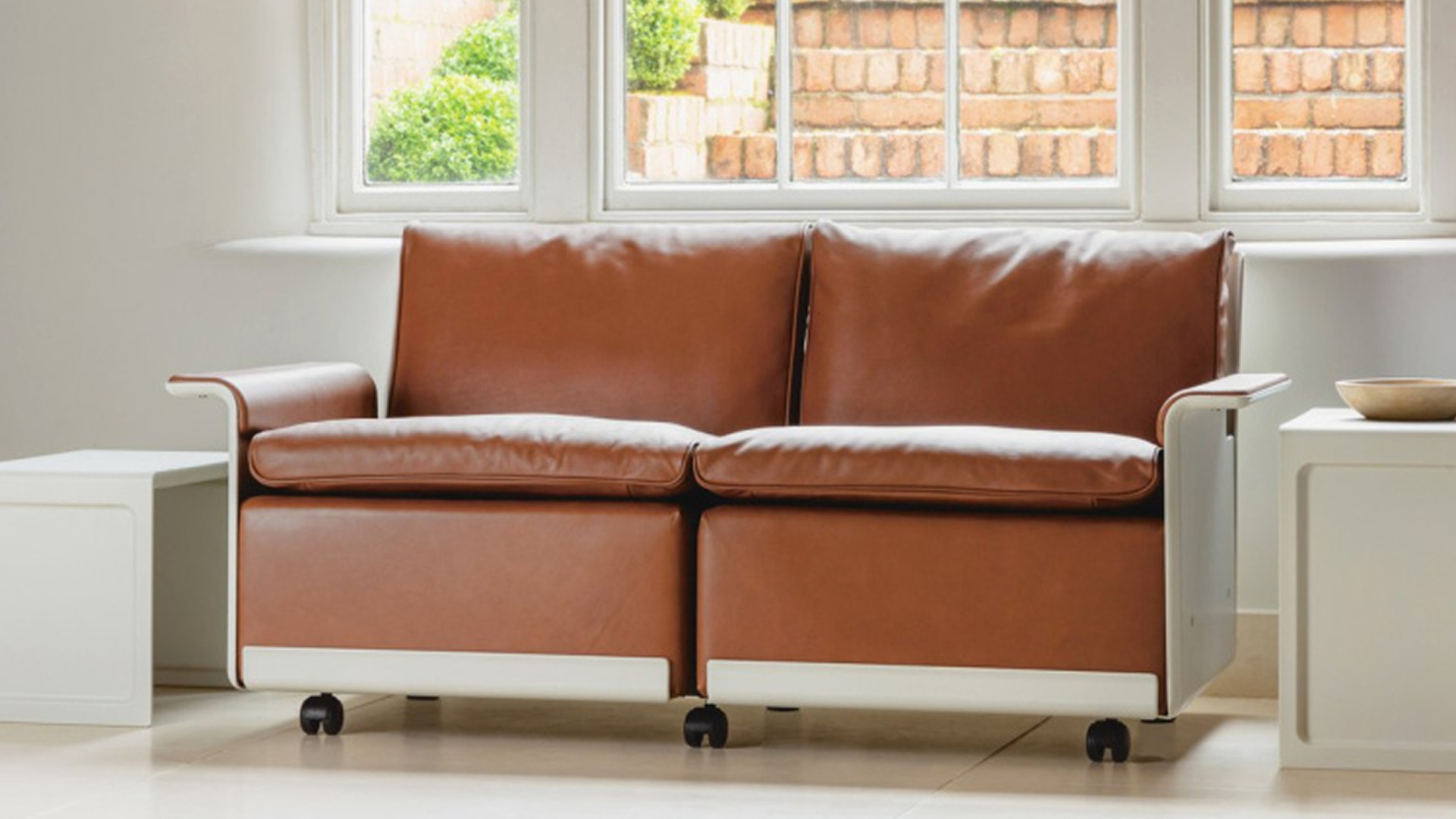 Vitsœ 620 modular sofa in cinnamon leather upholstery with off-white shell and two 621 tables on both sides